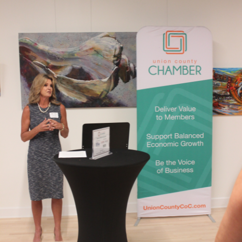 Woman speaking in front of Union County Chamber Banner