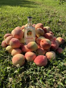 Peach Brandy bottle with peaches around it